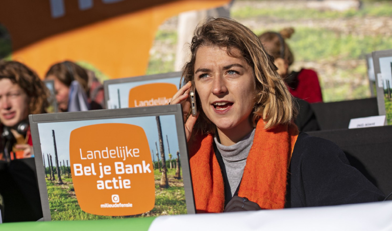 Moeder met kind op haar arm die in actie komt voor gezonde lucht.