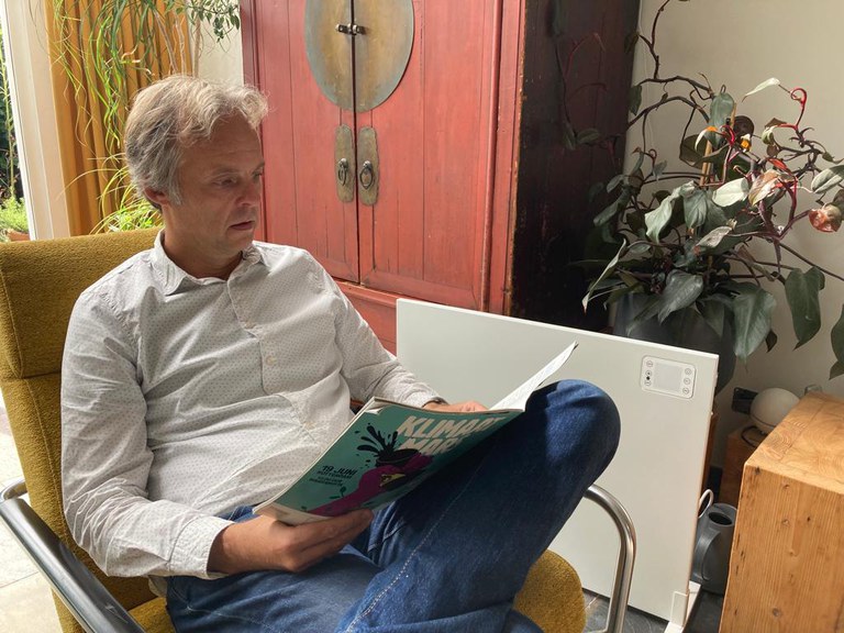 Man leest tijdschrift naast een infrarood verwarmingspaneel