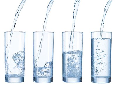 Vier glazen waarin kraanwater wordt geschonken