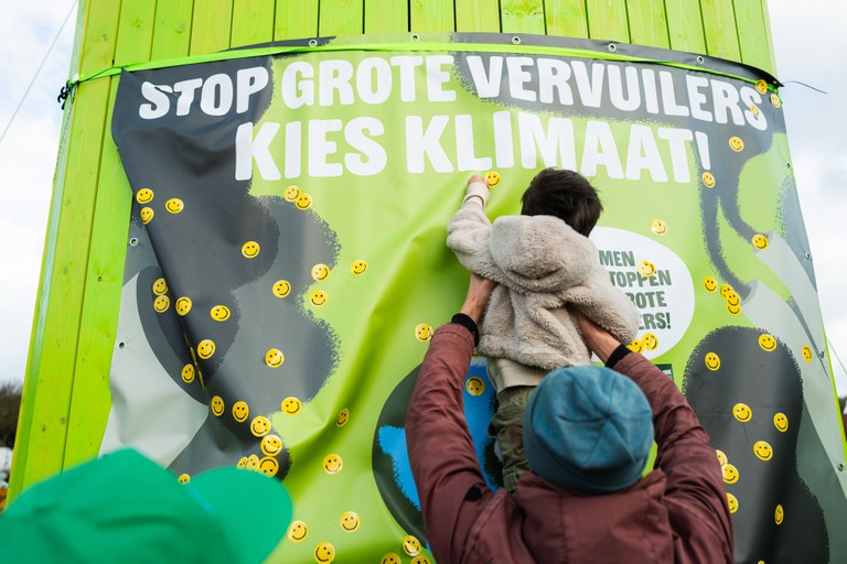 Kleine kindjes plakken smileys over de grote vervuilers (Foto door Edo Landwhehr)