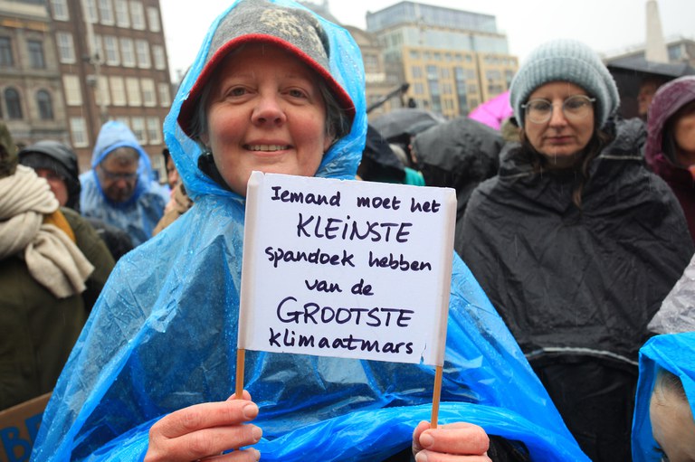 Protestbord Klimaatmars: 'Iemand moet het KLEINSTE spandoek hebben van de GROOTSTE Klimaatmars.' Fotograaf: Arie Kievit.