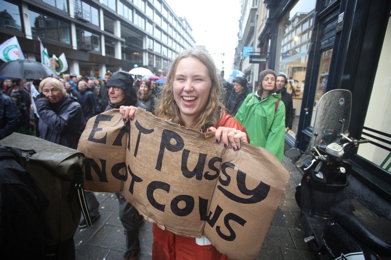 Activist op de Klimaatmars met een protestbord met de tekst: Eat pussy, not cows'. Fotograaf Arie Kievit
