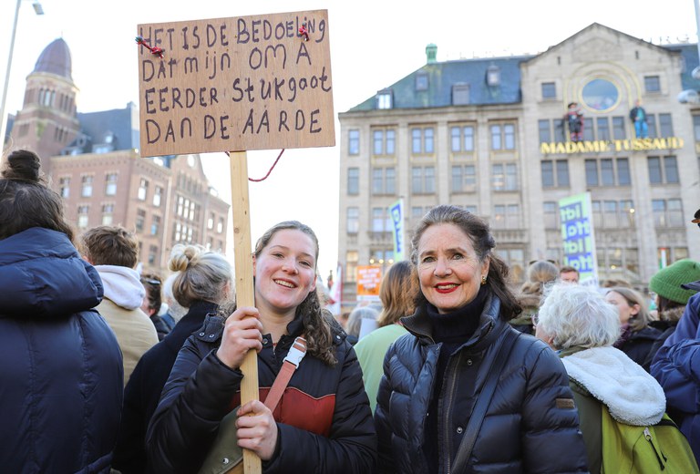 Een oma, een kleindochter op de Klimaatmars met een protestbord in de hand van kleindochter: 'Het is de bedoeling dat mijn oma eerder stukgaat dan de aarde.' Fotograaf: Ebru Aydin.