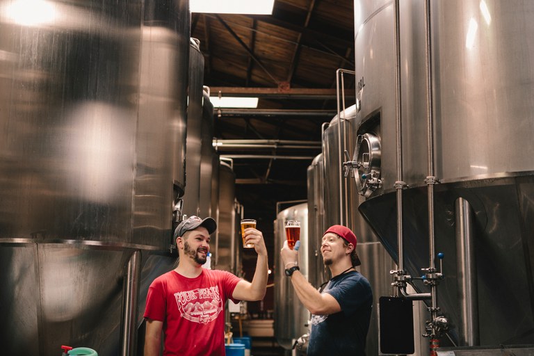 Foto: 2 brouwers bekijken bier dat net is gebrouwen.