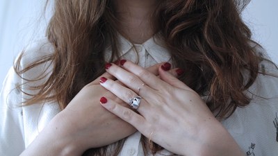 Persoon met lang bruin haar met handen over elkaar op de borst als teken van waardering 