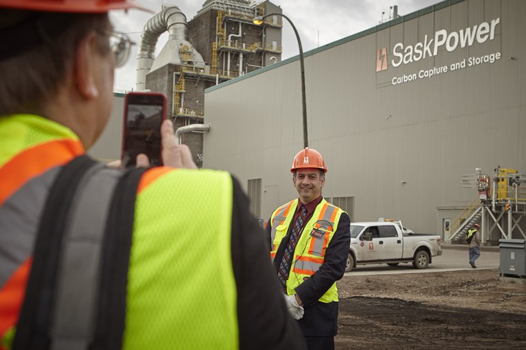 Slechte duurzame oplossingen - CCS CO2 opslag.jpeg Foto van een fabriek waar ze CO2 opslaan (Carbon Capture Storage). Op de voorgrond 2 werknemers: de ene man maakt een foto van de andere man.